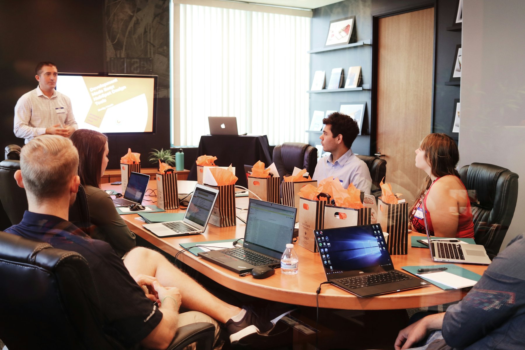 A project discussion around a conference table with laptops